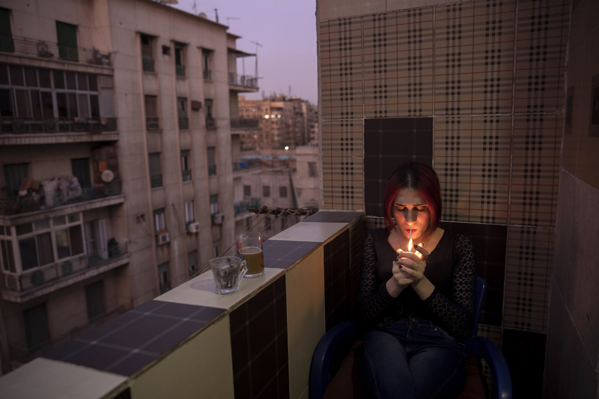 Malak el-Kashif smokes a cigarette in the balcony of her apartment in Cairo, Egypt. (AP Photo/Nariman El-Mofty